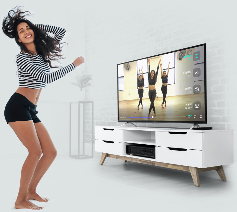 Dancer practising beside a television showing a dance lesson